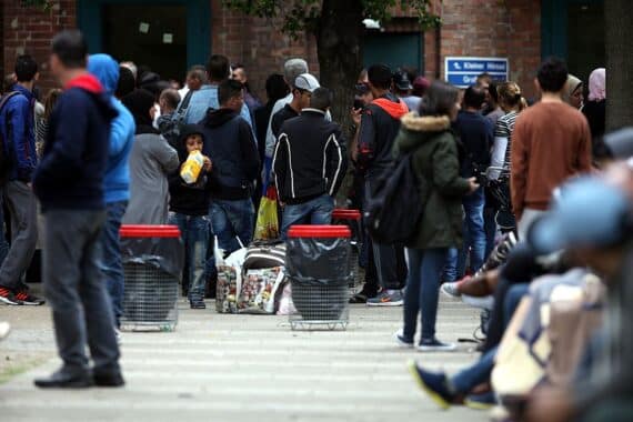 Flüchtlinge an einer Aufnahmestelle, wartend auf Aufenthaltstitel aufgrund technischer Probleme.