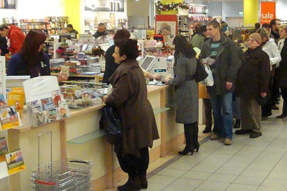 Ein Kaufhaus mit Kunden, die Produkte betrachten und einkaufen, symbolisiert den Einzelhandel.