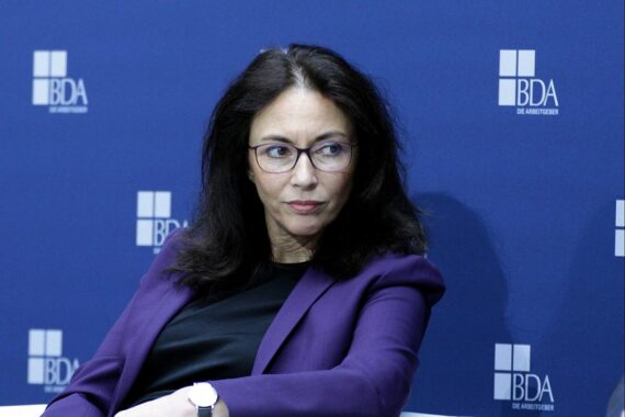 Yasmin Fahimi spricht über Mindestlohnerhöhung, am Tisch mit Kommission und Arbeitgebervertretern.