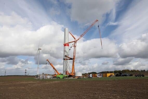 Windräder im Bau vor einer trockenen, von Dürre geprägten Landschaft als Symbol für Klimaschutz.