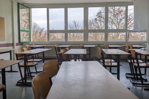 Klassenraum mit leeren Tischen, Symbol für aktuelle Bedrohungen an Schulen in Deutschland.
