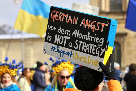 Proteste für und gegen Waffenlieferungen an die Ukraine, unterstützt von Menschen mit Plakaten.