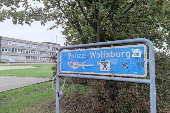 Drei festgenommene Männer, gestohlene E-Bikes und Polizeifahrzeuge auf VW-Parkplatz in Wolfsburg.