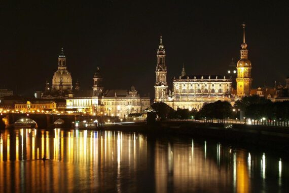 Dresden bei Nacht, leuchtende Stadtansichten, symbolisiert finanzielles Wachstum und Herausforderungen im Haushalt.