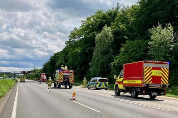 Elektrofahrzeug brennt auf A3, Feuerwehr im Einsatz, Fahrer schwer verletzt, Rettungshubschrauber eingetroffen.