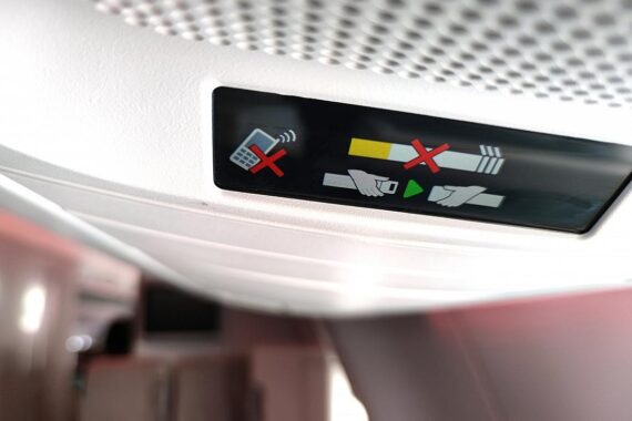 Fluggäste im Flugzeug, beeindruckt von Smartphones, ignorieren oft den "Flugmodus".