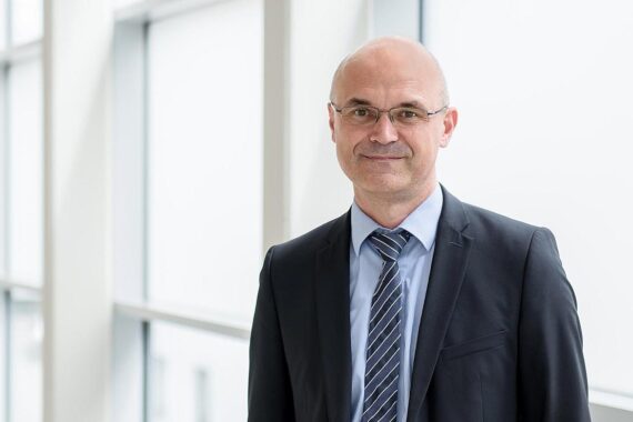 Professor Dirk Vordermark in akademischer Umgebung, symbolisiert Fortschritt in der Radioonkologie und Gesundheitspolitik.