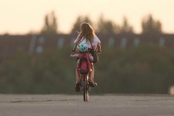 Frau mit Kind im Freien, umgeben von sonnigem und warmem Frühsommerwetter in Hessen.