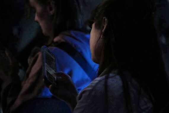 Junge Frau mit Smartphone, symbolisiert die Herausforderung der Radikalisierung durch soziale Medien.