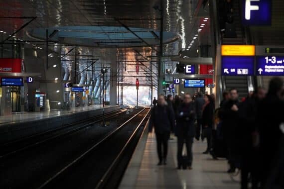 Reisende am Bahnhof mit Koffern, symbolisiert die Attraktivität des Bahnfahrens für Familien.