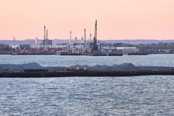 Industrieanlagen mit Stahlproduktion im Hintergrund, symbolisieren Handelskonflikt zwischen EU und USA.