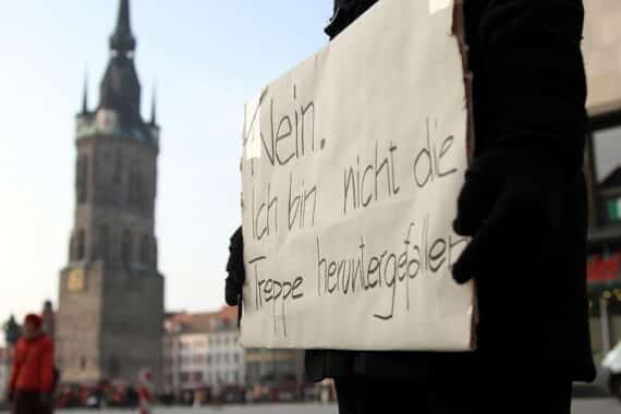 Demonstrantin hält Plakat gegen Gewalt an Frauen, symbolisiert den Kampf für Frauenrechte.