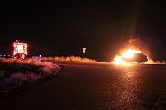 Pkw in Flammen auf Kreisstraße, Feuerwehr löscht Brand und schützt angrenzende Felder.