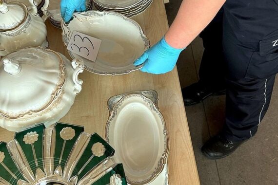 Ein Zollbeamter überprüft einen Transporter voller unverzolltem Porzellan und Küchenmessern.