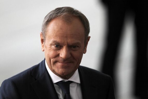 Donald Tusk im Parlament, umgeben von Abgeordneten, die über sein Vertrauen abstimmen.