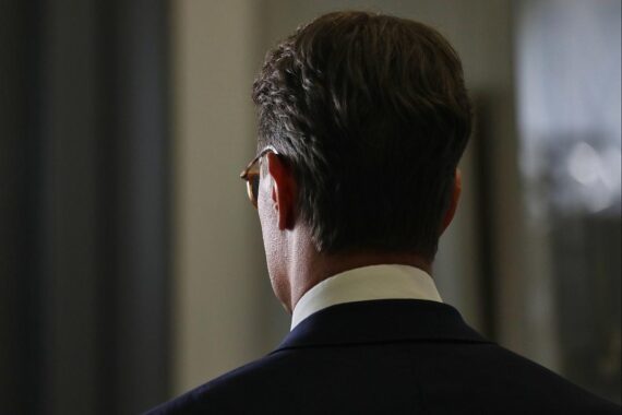 Hendrik Wüst steht vor dem Landtag, umgeben von kritischen SPD-Politikern und Medienvertretern.