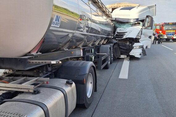 Schwerer LKW-Unfall auf A1: Rettungskräfte sichern Unfallstelle, verletzt Fahrer wird versorgt.