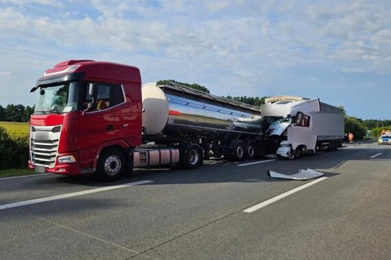 Zwei beschädigte Lastwagen auf Autobahn, Polizei und Trümmer, Unfallstelle mit gesperrter Fahrbahn.
