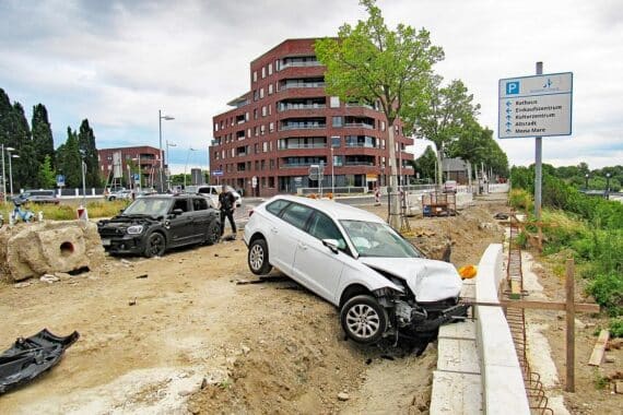 Zwei stark beschädigte Autos nach schwerem Unfall in Monheim am Rhein, Rettungskräfte vor Ort.