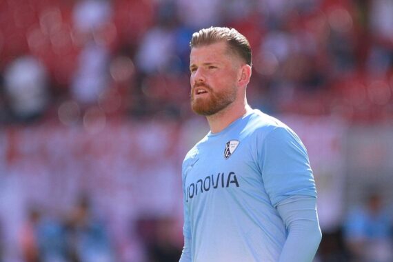 Timo Horn feiert Vertragsverlängerung mit VfL Bochum bis 2027, lächelnd in Torwartuniform.