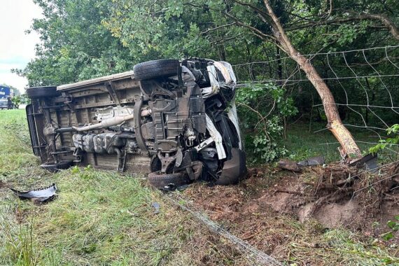 Ein umgestürzter Transporter im Böschungsbereich, Feuerwehrkräfte sichern die Unfallstelle.