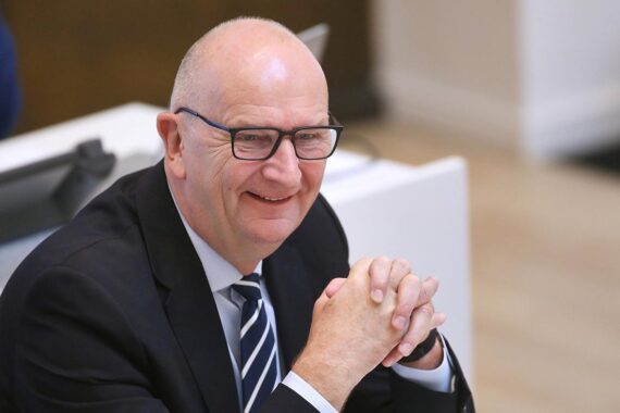 Dietmar Woidke, SPD-Landesvorsitzender, jubelnd auf dem Parteitag in Cottbus, mit Delegierten.