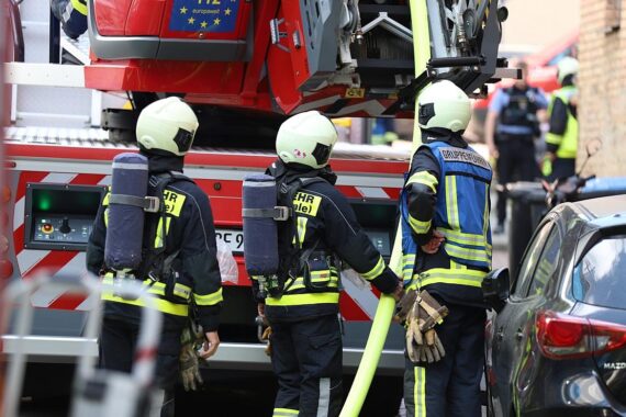 Feuerwehrteam löscht Wohnungsbrand, Opfer ist 89-jährige Frau, Brandursache unklar.