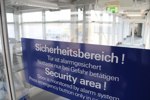 Flughafen-Sicherheitsbereich, unsichtbares Loch, Flüchtling entkommt, Polizei fahndet, Sicherheitsmaßnahmen erhöht.