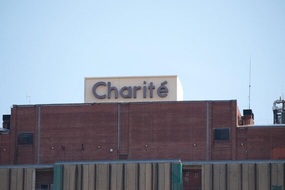 Eingang zur Charité mit Studenten, Symbol für geplante Studienplatzkürzungen in Berlin.