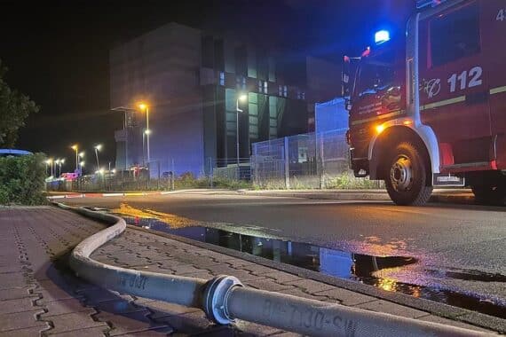 Feuerwehr beim Einsatz: Löschrohre und Schlauchleitung zur Kontrolle eines Müllbunkerbrands.