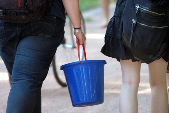 Zwei Frauen mit Wassereimer, symbolisieren das Wasserverbot in Chemnitz aufgrund niedriger Wasserstände.
