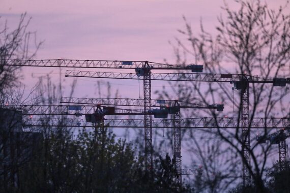 Baukräne in Berlin symbolisieren den stagnierenden Wohnungsbau und die politischen Herausforderungen.