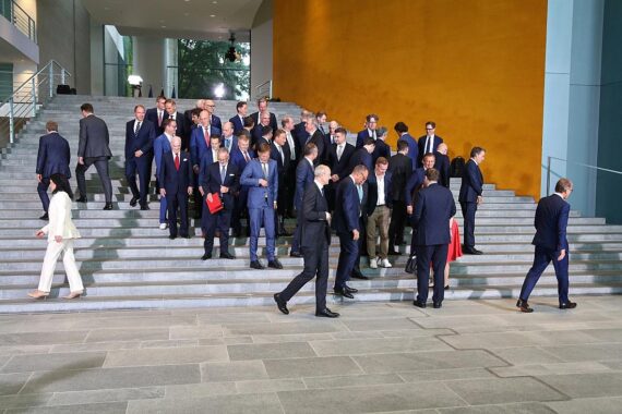 Gruppenfoto des Investitionsgipfels: wenige Frauen unter vielen männlichen Führungskräften, symbolisiert Ungleichheit.