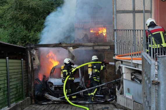 Großbrand in Schiffweiler: Zerstörter Carport, Flammen und Feuerwehr im Einsatz, verletzte Personen.