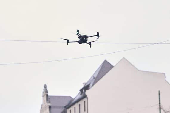 Drohne über kritischer Infrastruktur, symbolisiert Sicherheitsgefahren und notwendigen Handlungsbedarf der Politik.