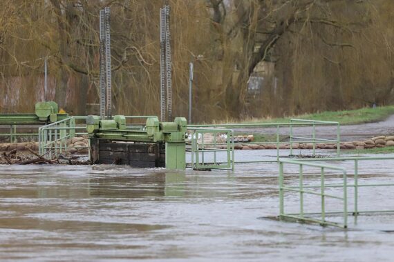 Ein Hochwasser, das ein Gebäude bedroht, symbolisiert die Gefahren durch den Klimawandel.