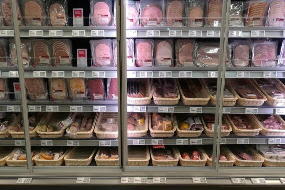 Ein Regal mit Fleisch und Wurst im Supermarkt, Symbol für Lebensmitteltransparenz und Kontrolle.