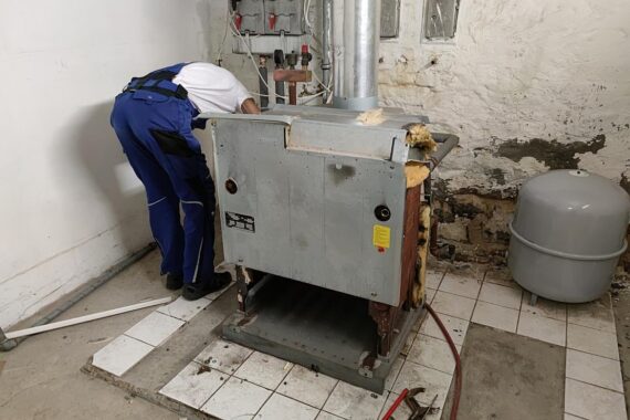 Arbeiter beim Ausbau einer alten Gasheizung, Symbol für stabilen Handwerkssektor in Baden-Württemberg.