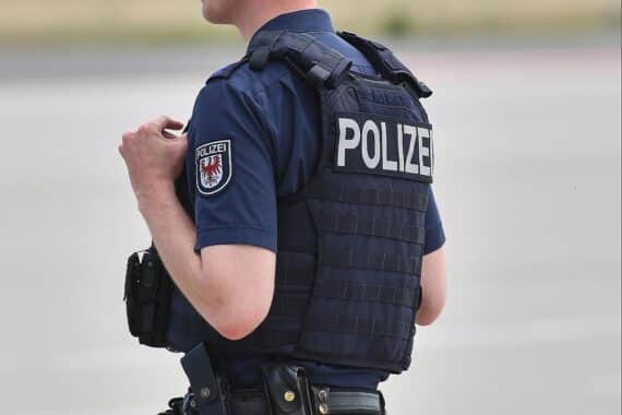 Ein Polizeiwagen vor einem Stadtbild, das Gewalt und Hilfsbereitschaft symbolisiert.