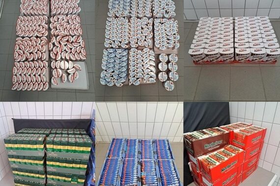 Polizisten präsentieren sichergestellte Schokolade und Kaffee nach Verkehrskontrolle in Hameln.