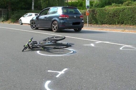 Unfallstelle mit Radfahrer, verletztem Pkw, Rettungskräften und Hubschrauber im Einsatz.