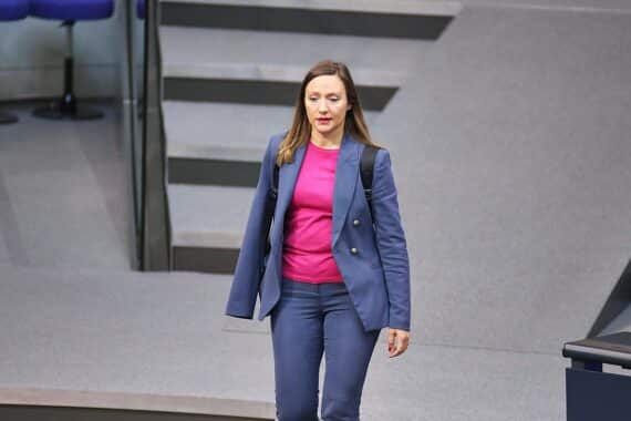 Bild von Jasmina Hostert, SPD-Politikerin, gegen Migrationsquoten in Schulen stehend, Schulumgebung.