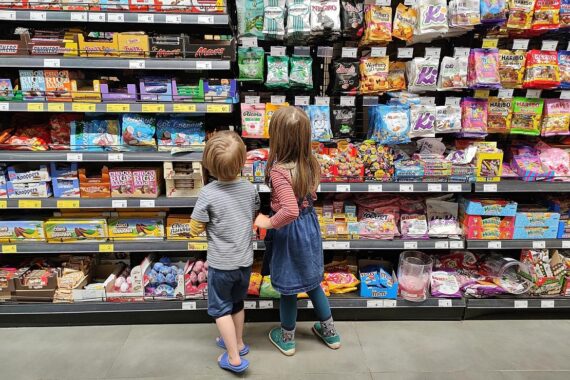 Kinder im Supermarkt, symbolisieren neue Regelung für Taschengeldkonten bei getrennten Eltern.