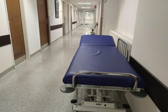 Krankenhaus mit medizinischem Personal, das Patienten betreut, symbolisiert steigende Gesundheitsausgaben und Finanzierung.