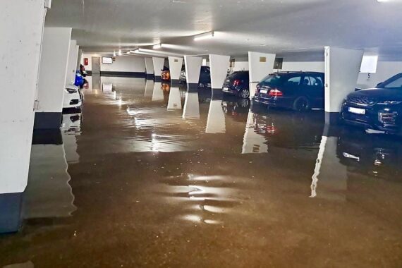Überschwemmtes Parkhaus nach Starkregen in Norderstedt mit Rettungskräften im Einsatz.