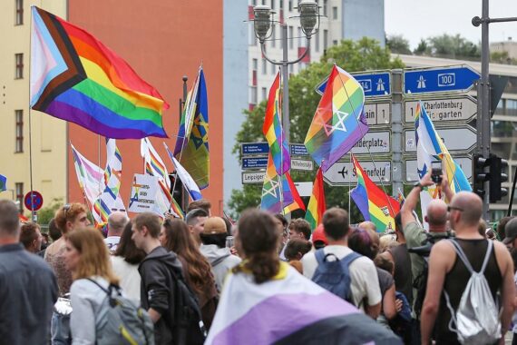 Buntes CSD-Feiern mit Regenbogenfahnen und Menschen, die Vielfalt und Toleranz zelebrieren.