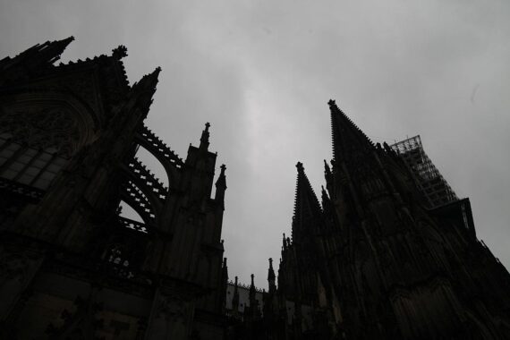 Kölner Dom unter grauen Wolken, symbolisiert wechselhaftes Wetter mit Schauern und Gewittern.