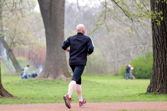 Jogger dehnen sich, um Beweglichkeit zu steigern und Muskelsteifigkeit zu reduzieren.