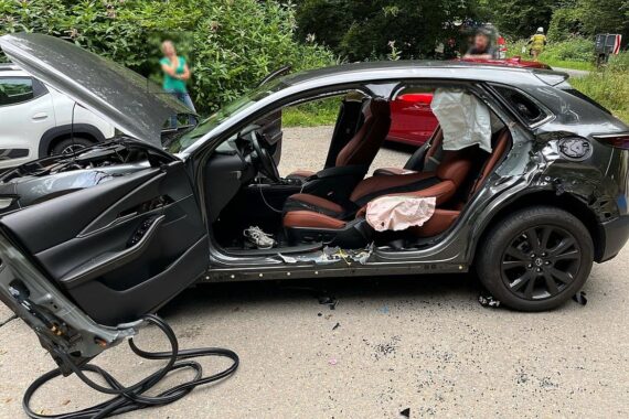 Zwei beschädigte Autos nach einem Unfall auf der Scherfbachtalstraße, Rettungskräfte im Einsatz.