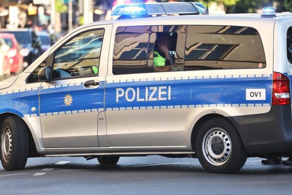 Ein zerstörter Opel, Baum und Polizei vor einem Unfallort in Bramsche.